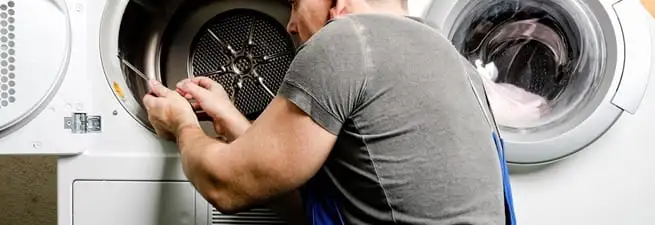 Dryer repair technician fixing a clothes dryer drum in Lowell, MA