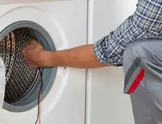 Dryer repair technician diagnosing and servicing a clothes dryer in Lowell, MA