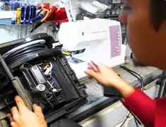 Vacuum repair technician servicing internal components on a workbench in Lowell, MA