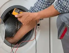 Washing machine repair technician testing a front-load washer with diagnostic tools in Lowell, MA
